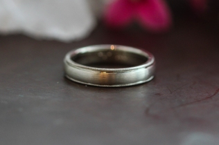 A low dome wedding band with a classic milgrain edge and a brushed finish